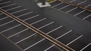 Aerial view of an empty outdoor parking lot with freshly painted white parking lines and no vehicles present.