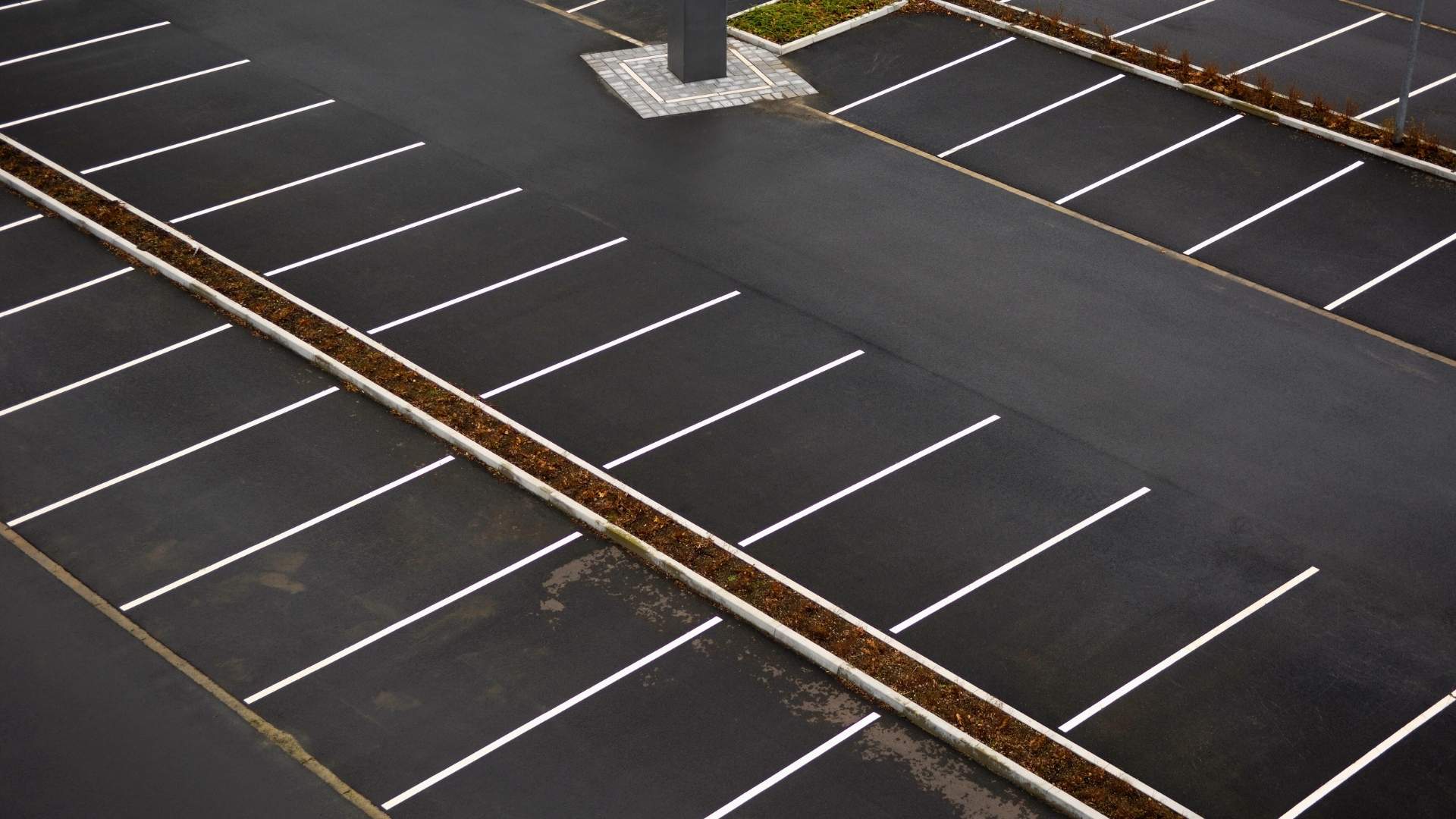 parking lot paving michigan An empty parking lot with freshly painted white lines marking parking spaces, viewed from above.