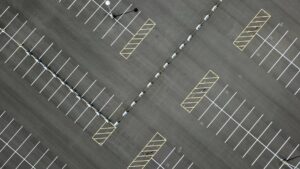 Top down view of paved parking lot with stripped parking spaces and no cars visible