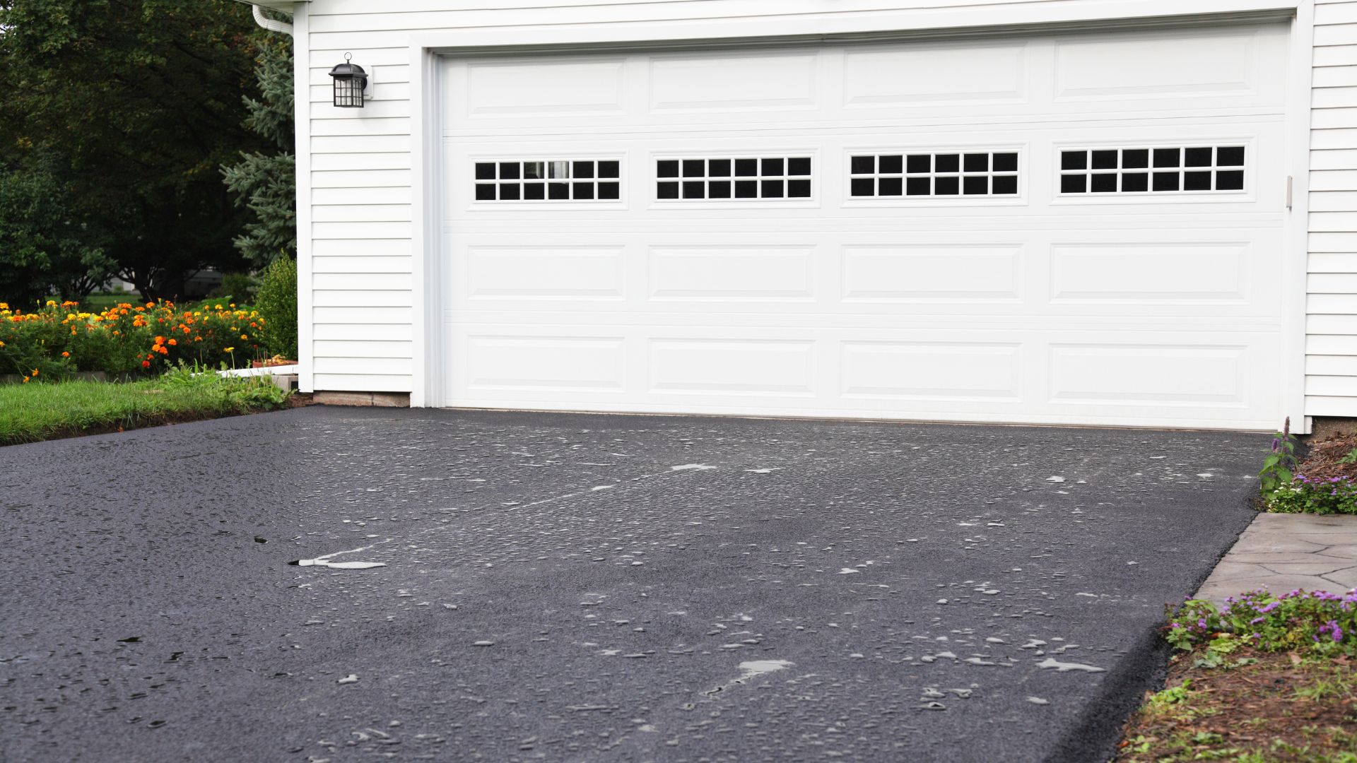 asphalt driveway leading to a white 2 car garage