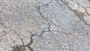 Close-up of weathered asphalt pavement with extensive alligator cracking.